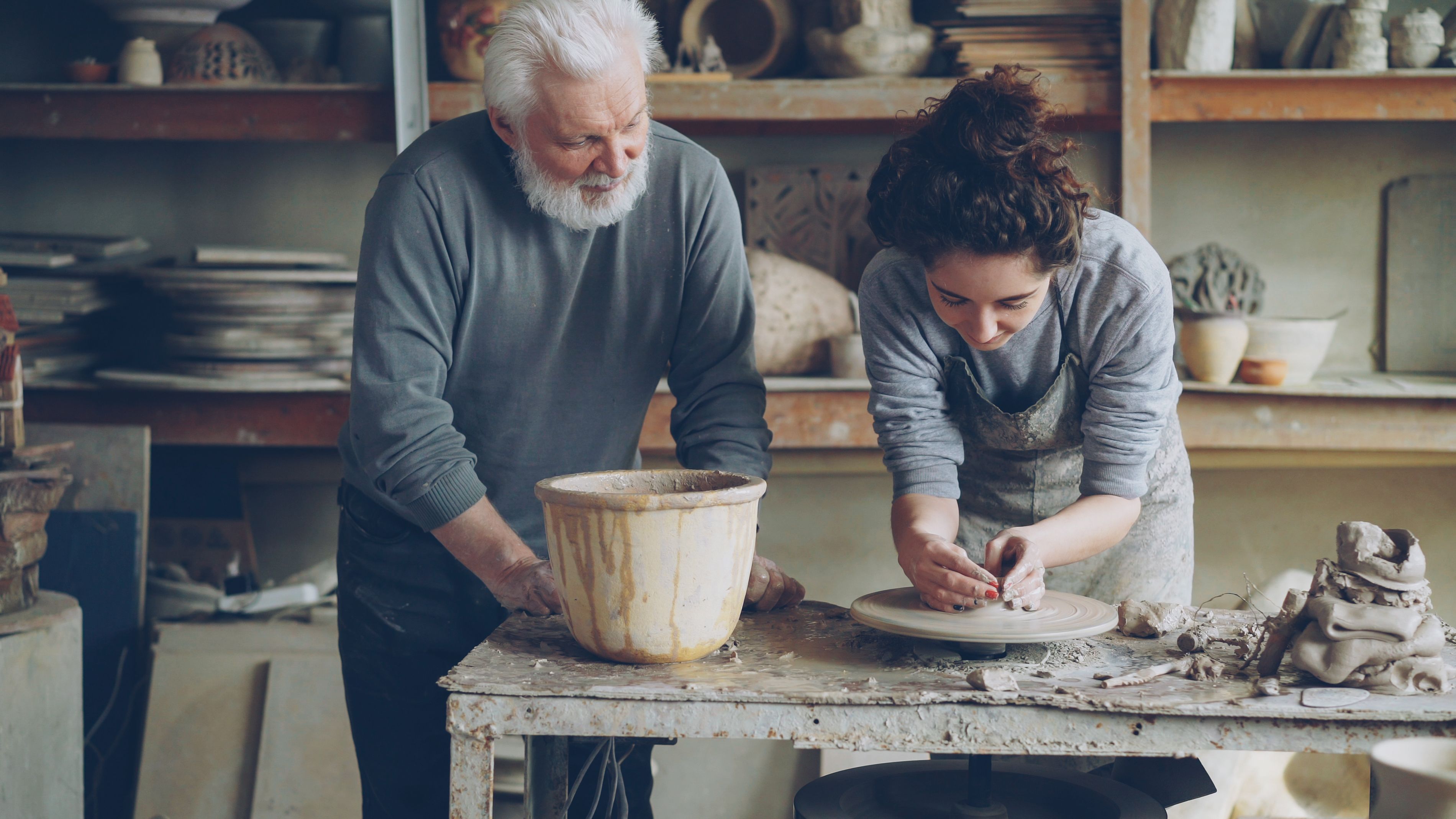 An Oga (master) guiding a young potter in a studio